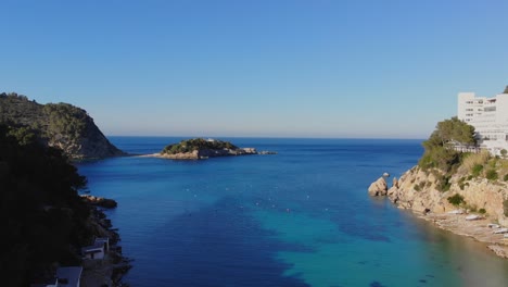 drone rising by a small bay on ibiza