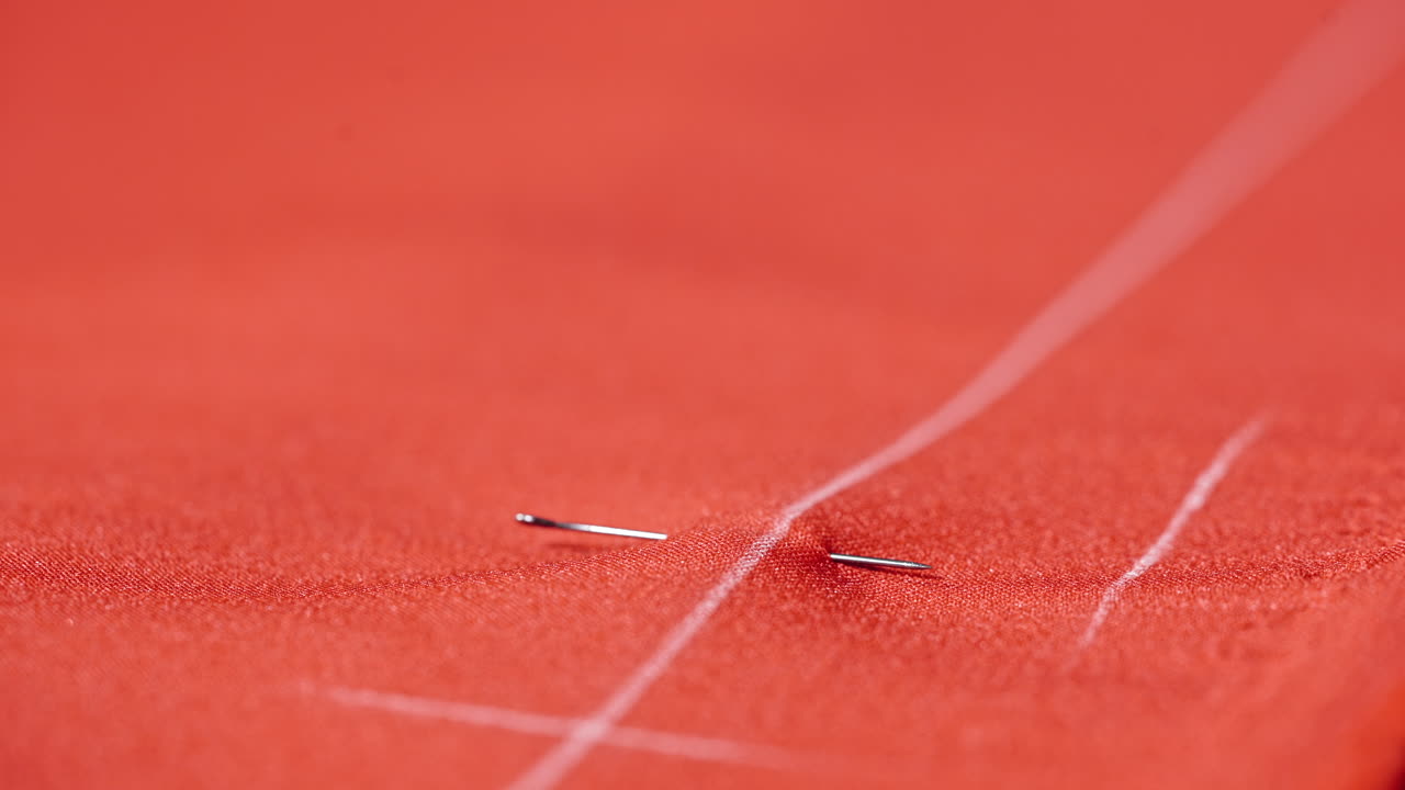 Seamstress working at table in atelier. Close up of woman seamstress making pattern on fabric with chalk