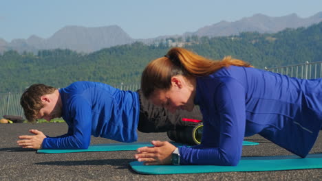 couple doing plank exercises outdoors