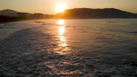 Sunset-on-the-beach,-with-birds-and-seen-from-a-drone