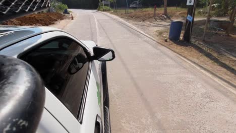 Right-Side-View-Of-A-Car-Driving-On-The-Asphalt-Road-To-Khao-Sok-In-Thailand---rolling-shot