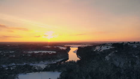 la vista aérea del bosque invernal cubierto de nieve a tiempo al atardecer en vísperas de navidad.