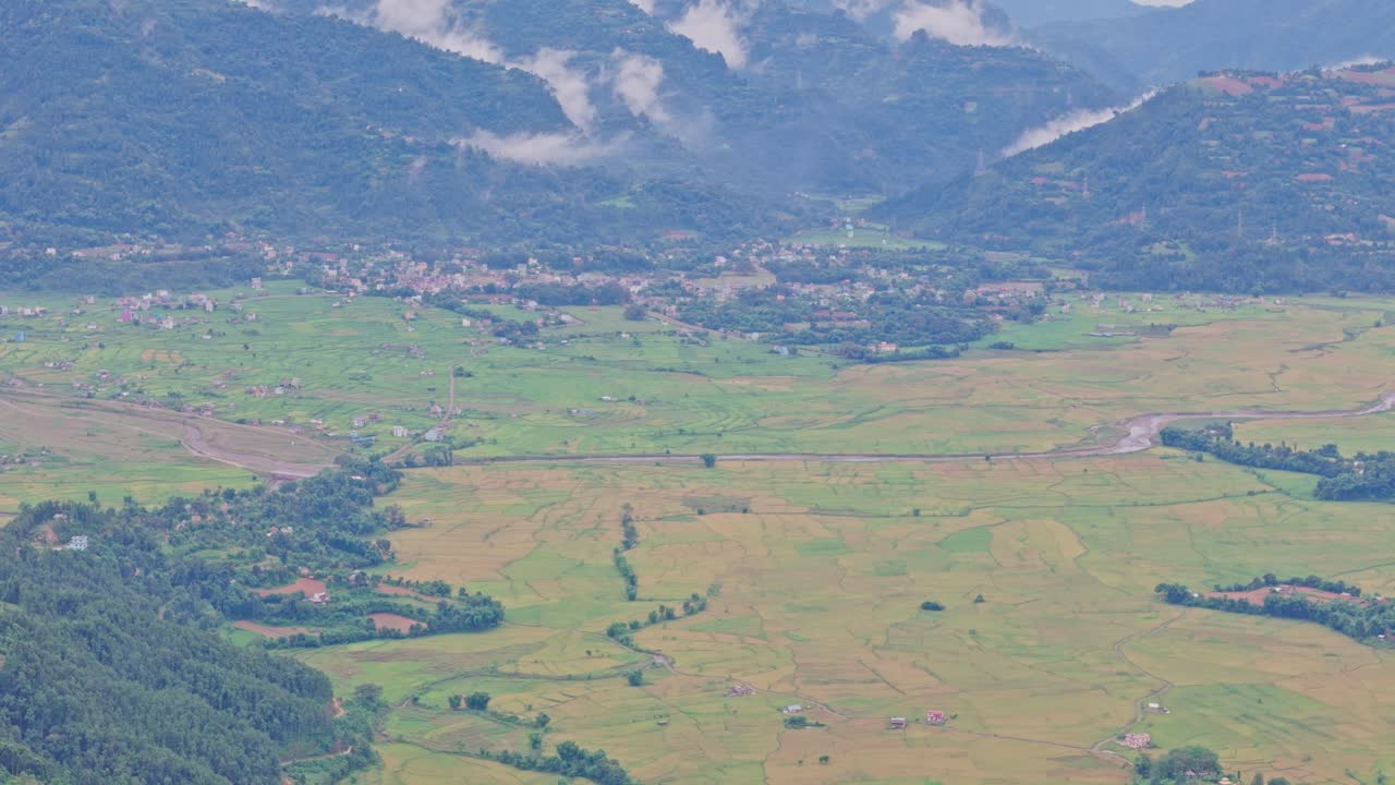 Aerial view of lush green paddy fields in Tansen Palpa, Nepal, surrounded by beautiful mountains and rural landscapes, showcasing the region’s rich agriculture and natural beauty