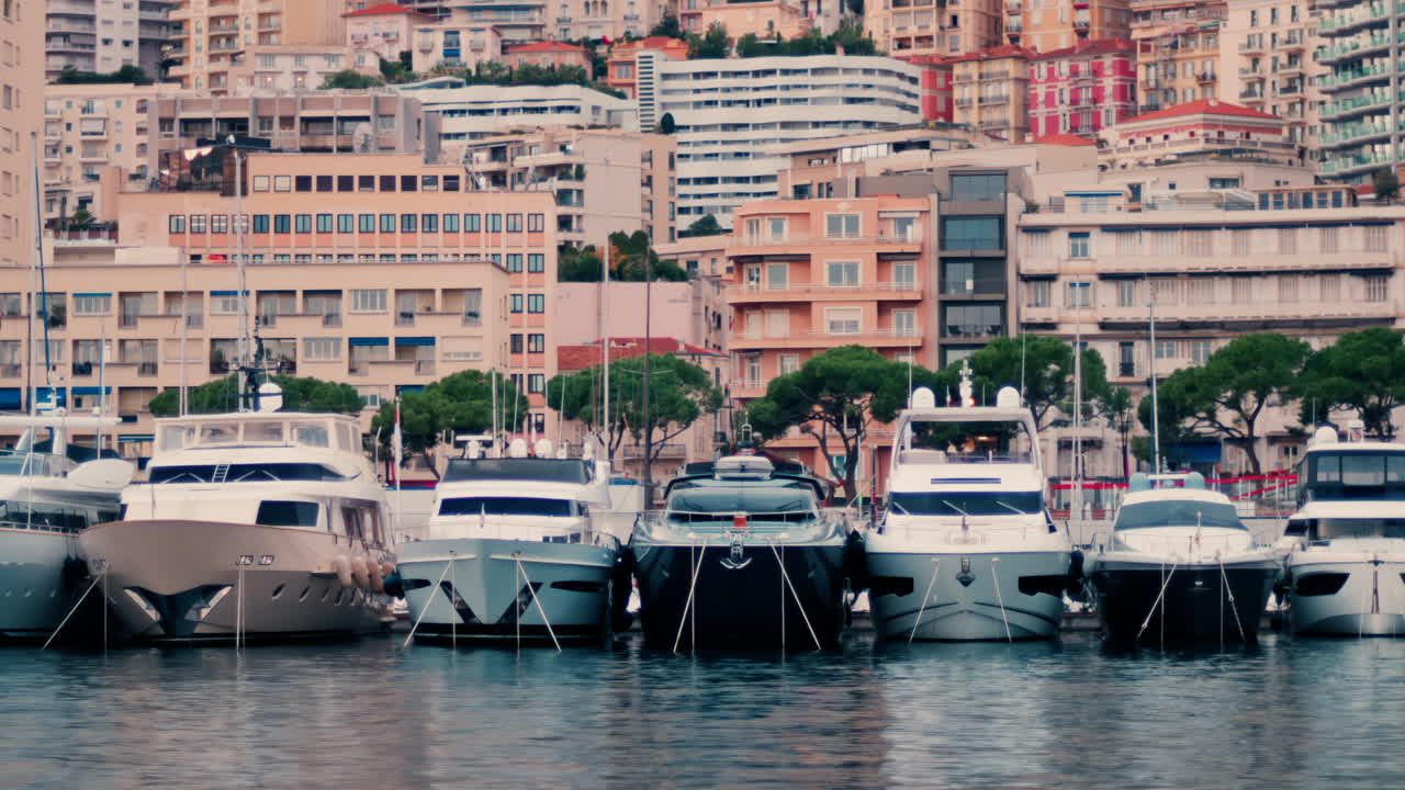 View of boats docked in the Monaco Marina with the skyline of the city on the background