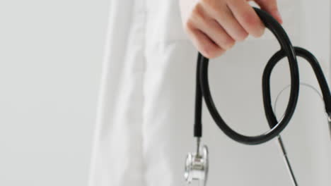 video of midsection of caucasian doctor holding stethoscope, with copy space