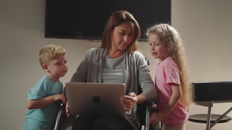 niños curiosos miran a la madre independiente trabajando en la computadora portátil