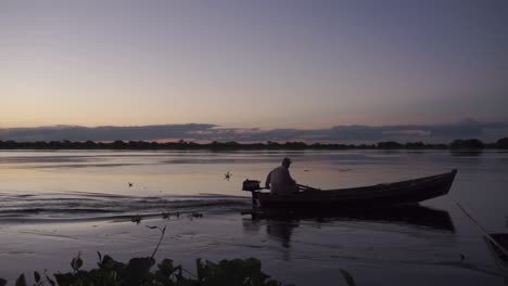 Silhouette-Eines-Einsamen-Fischers,-Der-Während-Der-Blauen-Stunde-Mit-Seinem-Boot-Segelt