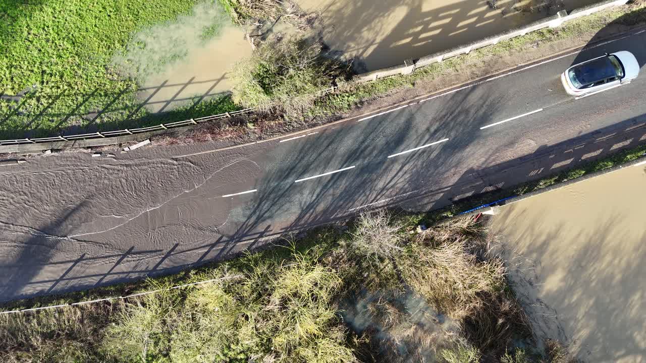 Overhead birds eye drone aerial view Cars driving through flooded road Essex UK