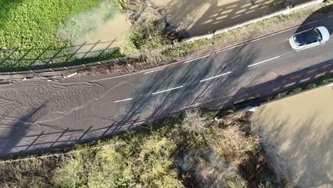 overhead birds eye drone aerial view cars driving through flooded road essex uk