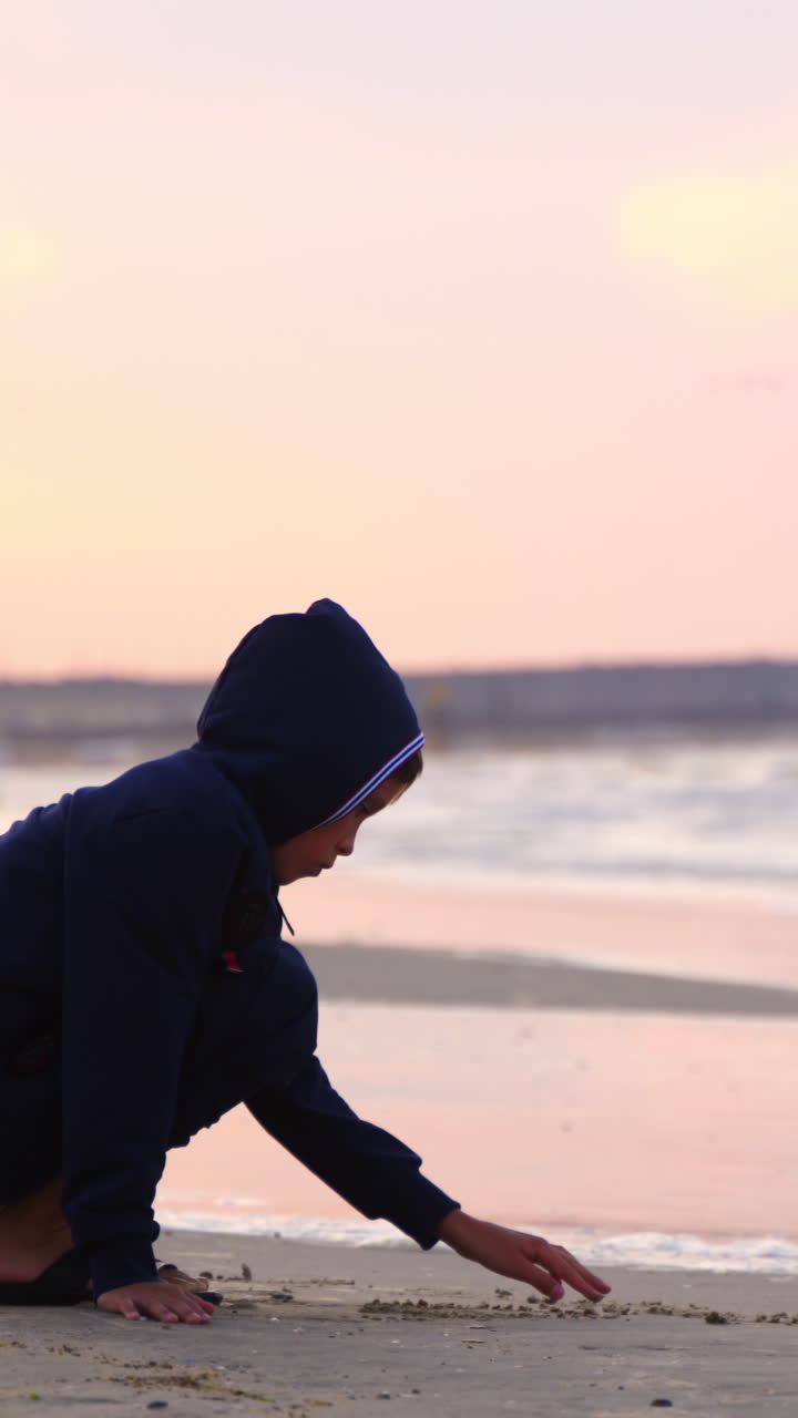 Bambino che scrive parole sulla sabbia. Piccolo bambino che scrive sulla sabbia della spiaggia.