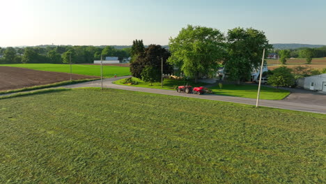 Aerial-approach-towards-red-tractor-with-baler-attached