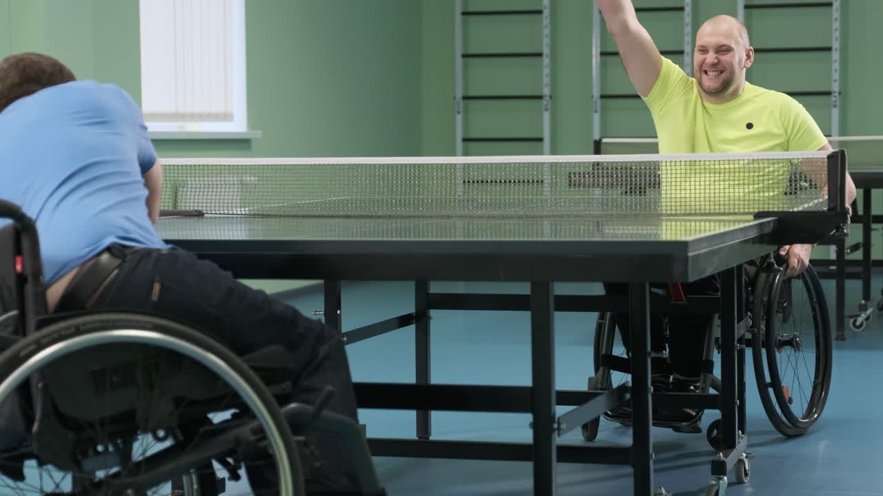 체어에 앉아 있는 남자가 핑핑을 하고, 장애인들이 탁구를 하고, 장애인의 재활, 패럴림픽 스포츠.