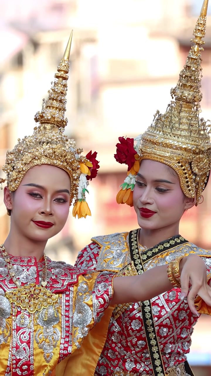 Due ballerine in sontuosi costumi dorati eseguono la tradizionale danza Khon al Wat Suthat.