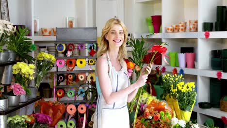Female-florist-arranging-flowers-in-flower-shop