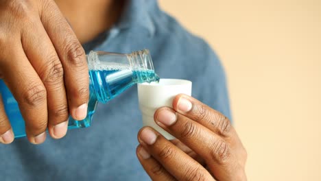 pouring mouthwash into a cup