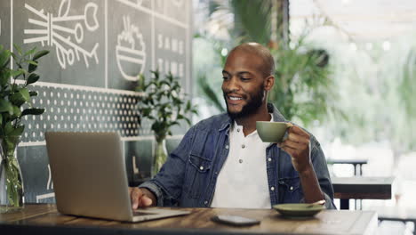 a young man having coffee and using a laptop