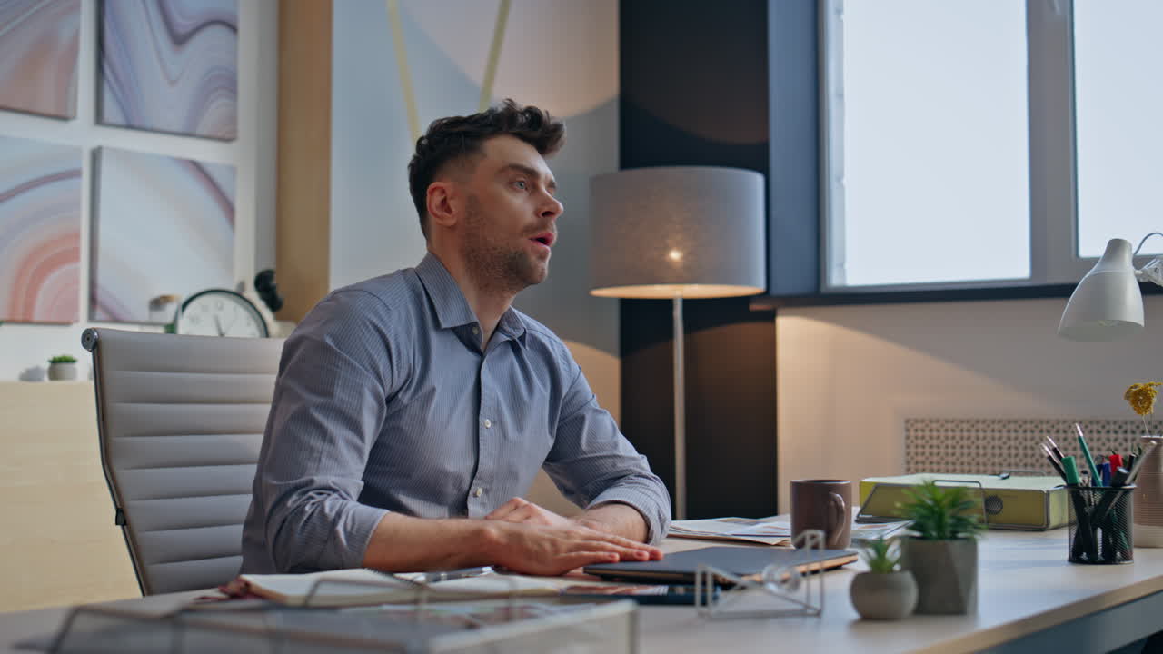 Hardworking man closing laptop at cozy office workplace closeup. Exhausted guy