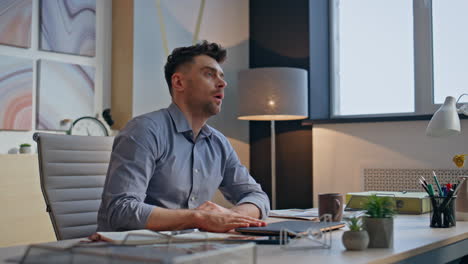 hardworking man closing laptop at cozy office workplace closeup. exhausted guy