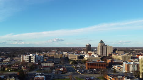 tomada aérea de 4k moviéndose hacia el centro de greensboro, capturando el horizonte contra un telón de fondo de un hermoso cielo