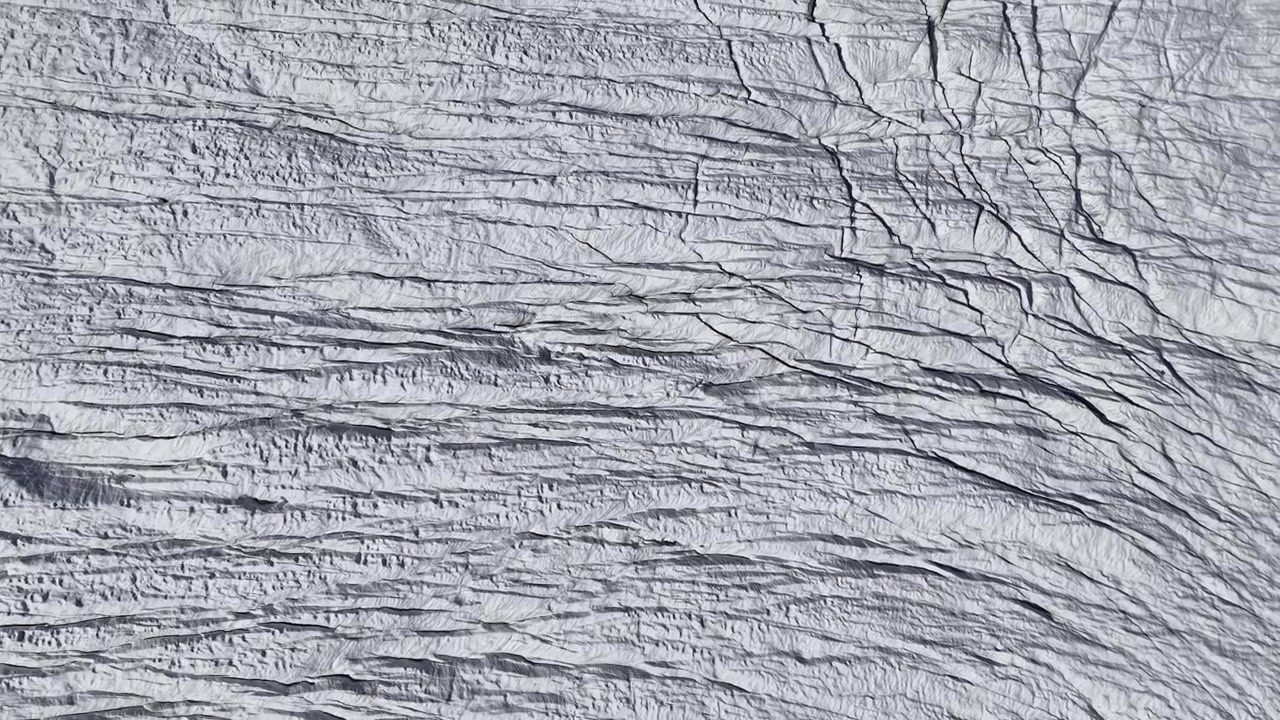 Aerial flyover over the Gorner glacier at Gornergrat in Zermatt, Switzerland with a top down view of the icy crevasses