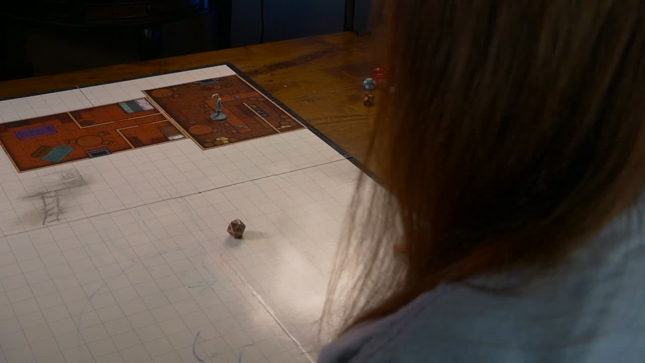 женщина бросает металлический двадцатигранный кубик на игровой коврик