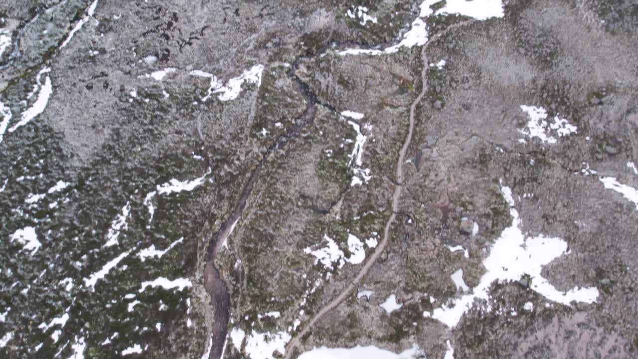 imágenes aéreas de drones sobre un páramo remoto en las tierras altas, inclinándose para revelar parches de nieve, montañas, un río y páramos helados en invierno