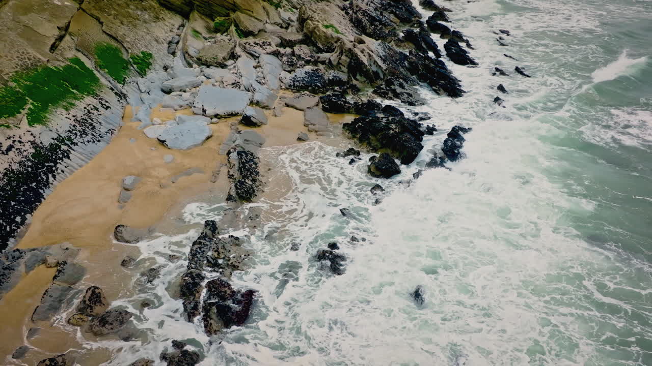 Super slow motion atlantic ocean waves hitting rocks on a beach