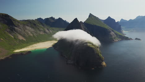 Toma-Cinematográfica-De-Un-Dron-Giratorio-De-La-Playa-De-Horseid-Con-Agua-Azul-Turquesa,-Nubes-Moviéndose-Sobre-Acantilados