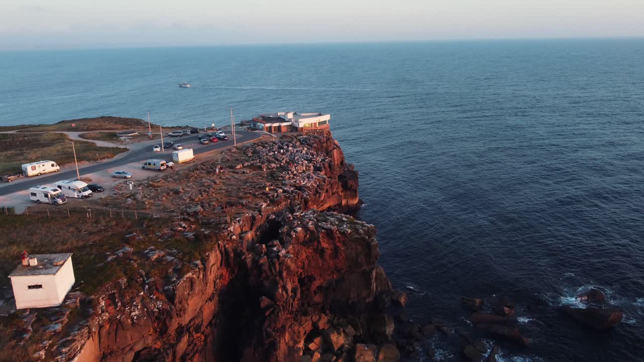 페니체에 있는 절벽의 드론 샷, 바다에 보트가 있는 포르투갈, 수평선에 일몰 - 공중