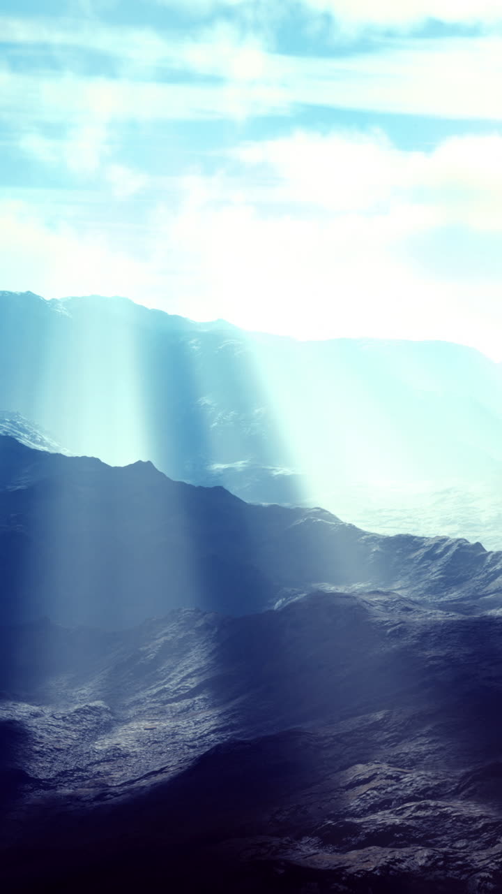 Majestic mountain landscape with ethereal light breaking through clouds