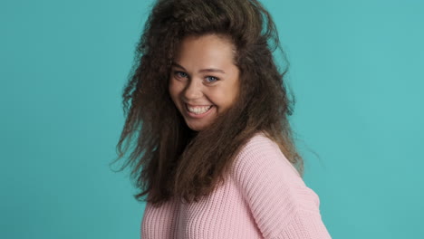 Caucasian-curly-haired-woman-with-thumb-up-in-front-of-the-camera.