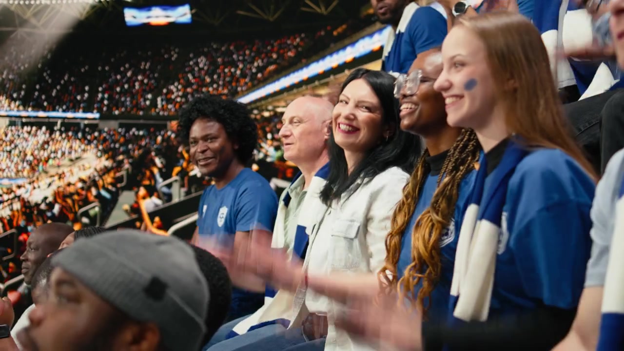 Soccer fans cheering and clapping during live football match in stadium stands