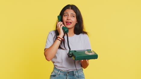 tired bored woman talking on wired vintage telephone exhausted of talk, making silly faces, fooling