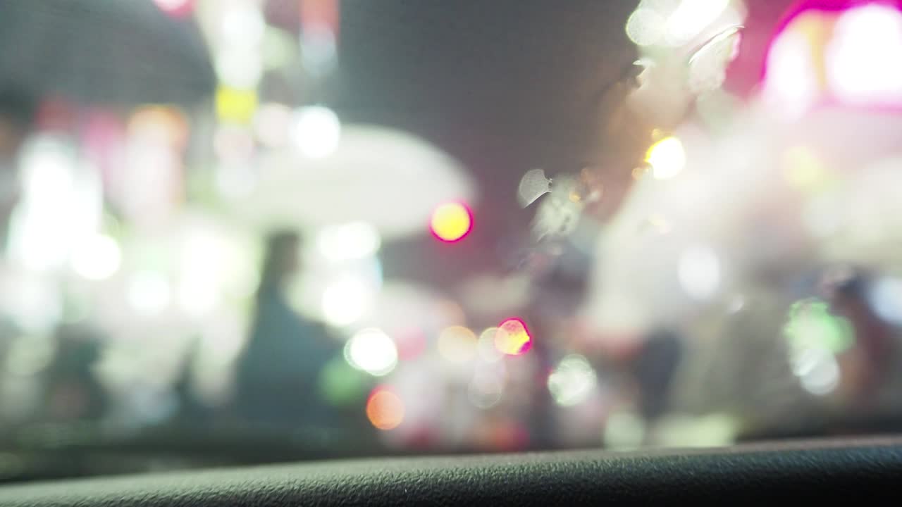 비가 내리는 도쿄 신주쿠의 교차로를 건너는 사람들