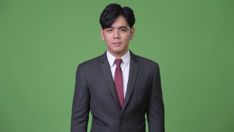 joven y guapo hombre de negocios asiático señalando con el dedo