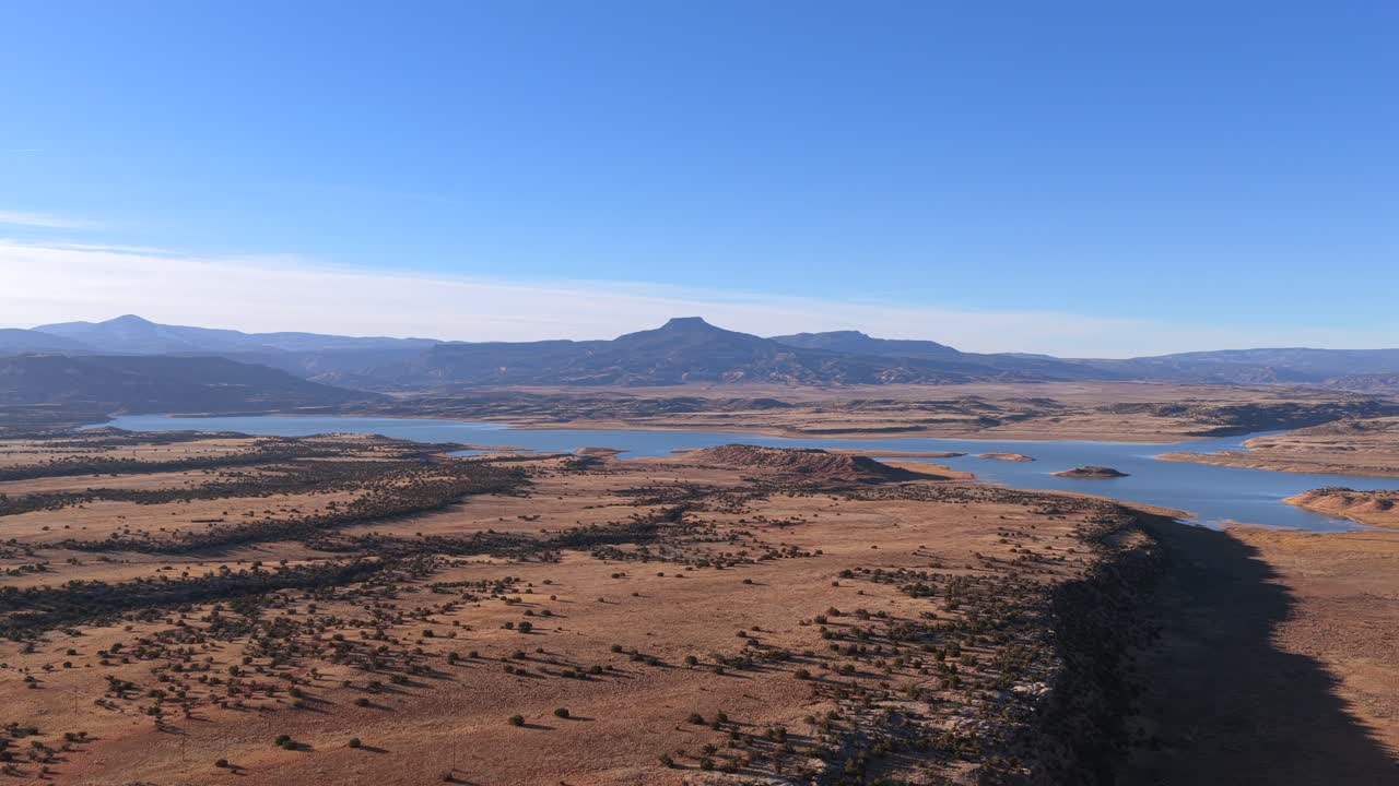 Un drammatico volo di drone si spinge verso l'iconica sagoma dalla cima piatta del Cerro Pedernal. Questa prospettiva cinematografica in 4K cattura il leggendario punto di riferimento del Nuovo Messico e la vasta natura selvaggia del Sud-ovest.