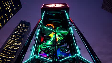 colorful illuminated clock tower at night in a city
