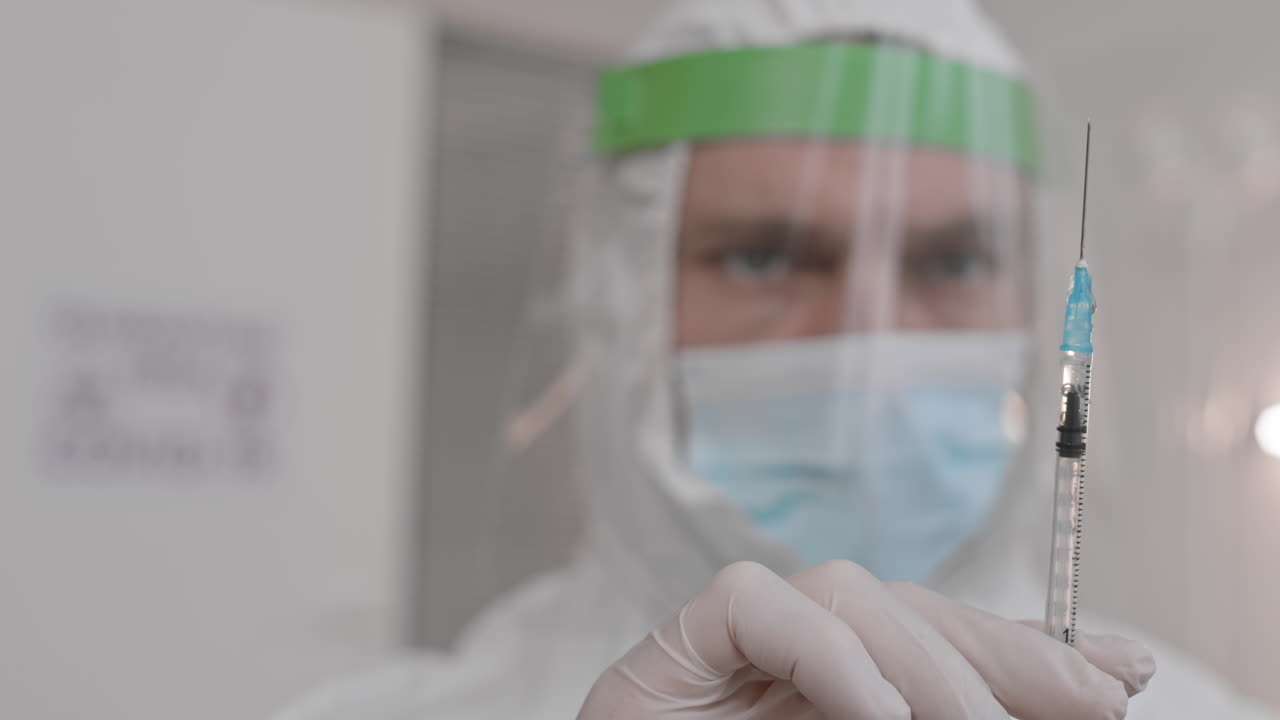 Blurred Doctor Tapping on Syringe