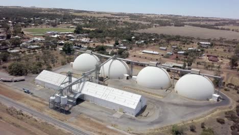 four dome silos ready to store harvested grain - orbiting aerial view