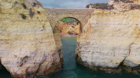 volar lejos en el puente del arco en paria dos estudiantes en lagos, algarve, portugal