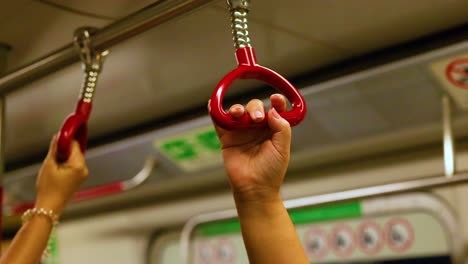 a hand grips a subway handle securely