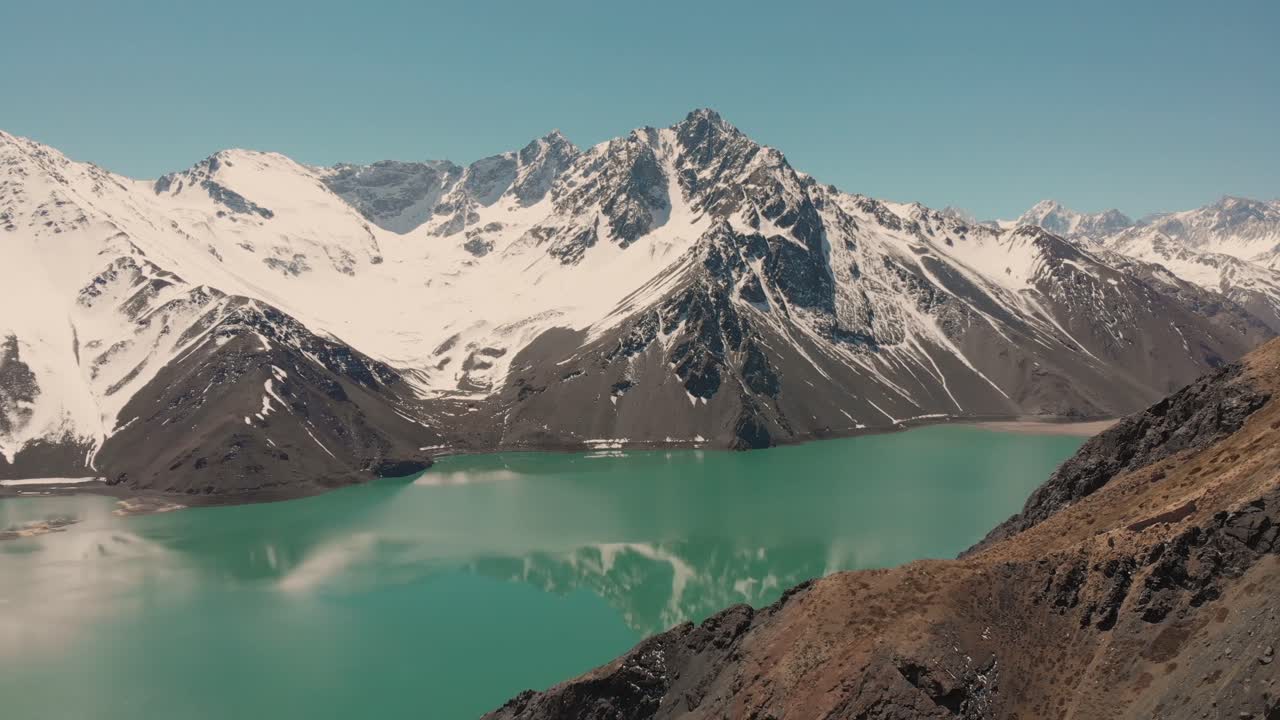 tiro ascendente sobre el embalse en las montañas de los andes que muestra la reflexión sobre el agua-4k