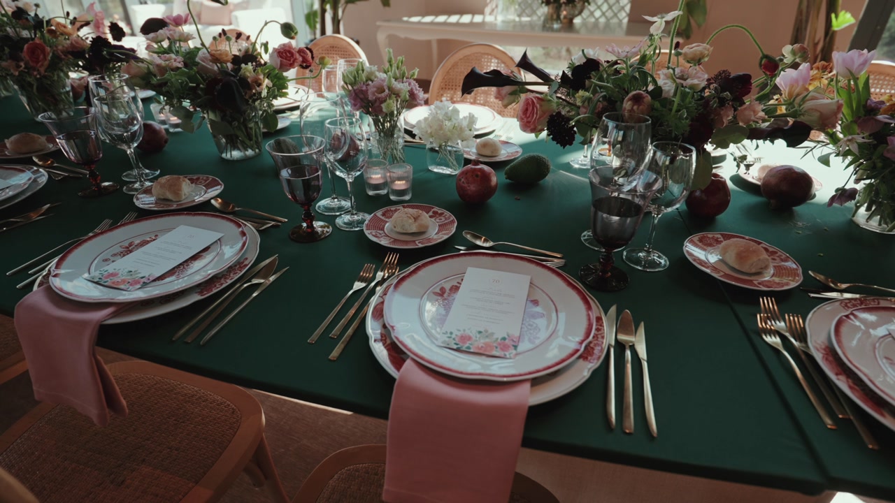 Decorated dining table with plates cutlery floral arrangements glassware candles and bread prepared for wedding reception