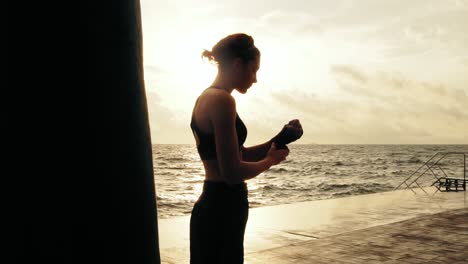 Mujer-Atlética-Preparando-Sus-Puños-Para-Los-Guantes-De-Boxeo-Envolviéndolos-Con-Una-Venda-Parada-Contra-El-Hijo.-Femenino