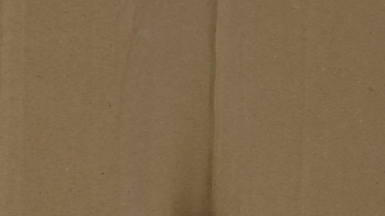 Moment of appearance of fire and strengthening of burning of cardboard. Blazing fire burns a hole in corrugated cardboard, turning it to ash and revealing blue screen chroma key. Close up. Slow motion