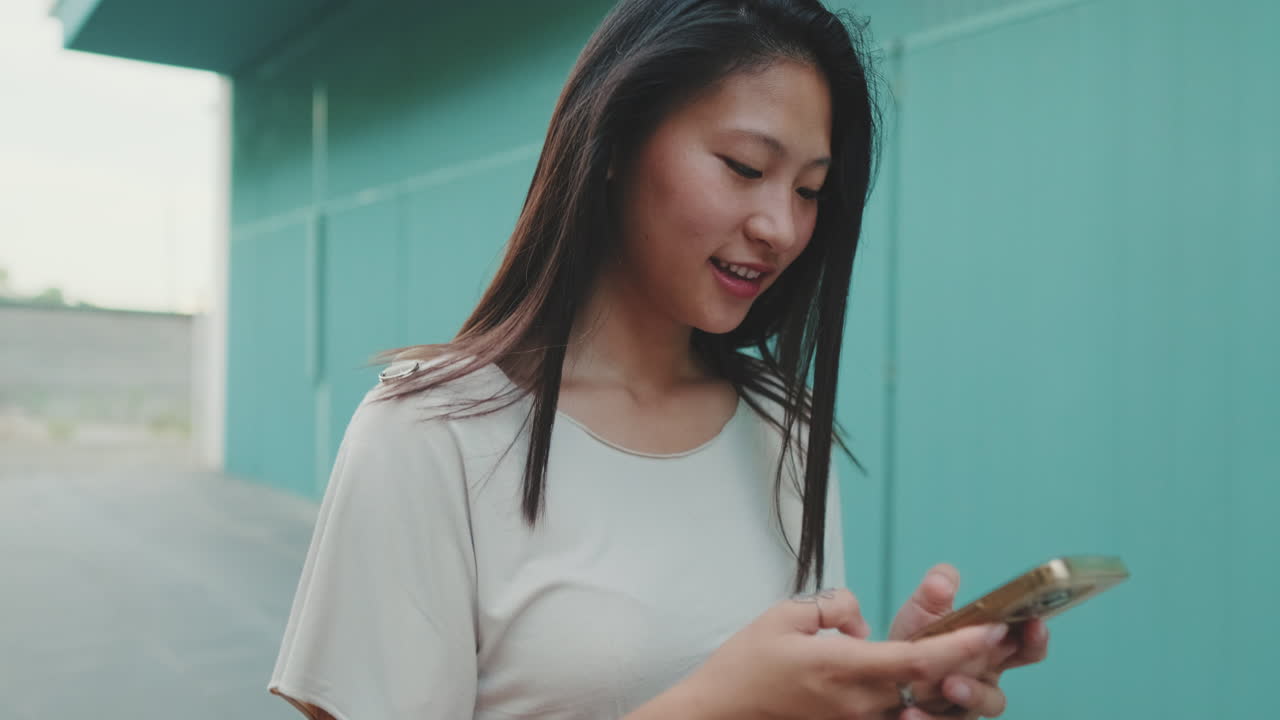 Asian woman using phone outdoors