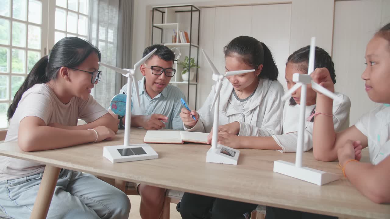Asian Group Of Thoughtful Kids Study About Ecology Problems And Their Solution With Wind Turbine Model And Globe At School. Renewable Energy