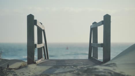 Red-buoy-float-floating-in-rough-sea-with-staircase-down-to-the-beach