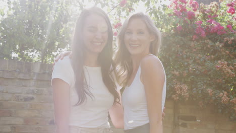 Portrait-Of-Female-Gay-Couple-At-Home-In-Garden-Against-Flaring-Sun-Together