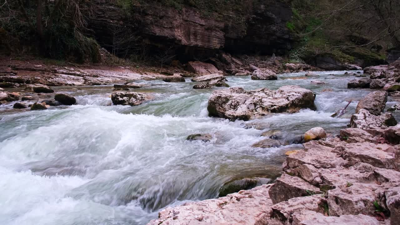 Un fiume di montagna roccioso scorre. Corrente forte e acqua ribollente, cascata. Il concetto di turismo, escursionismo, bellezza della natura selvaggia. 4k
